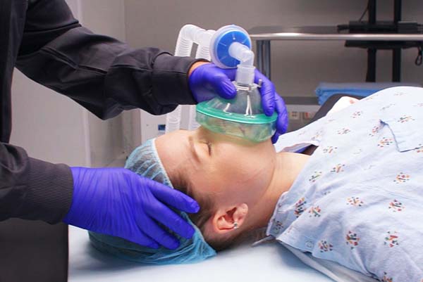 A person is getting his head cleaned by two hands.